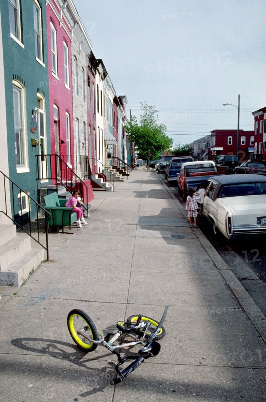 June 11, 1998 - small bike lying on sidewalk in urban neighborhood