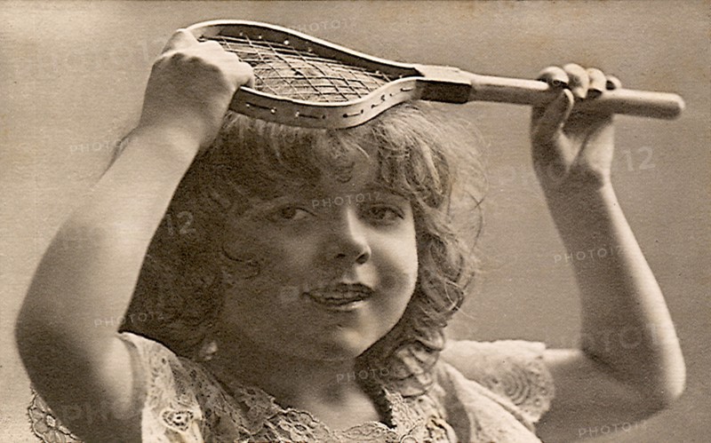 Young girl holding very little tennis racquet.
