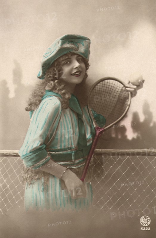 Woman in blue dress with Tennis Racquet and ball.