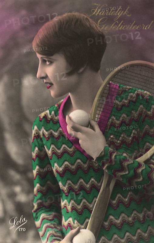 Woman with short hair & sweater with tennis racquet and ball.