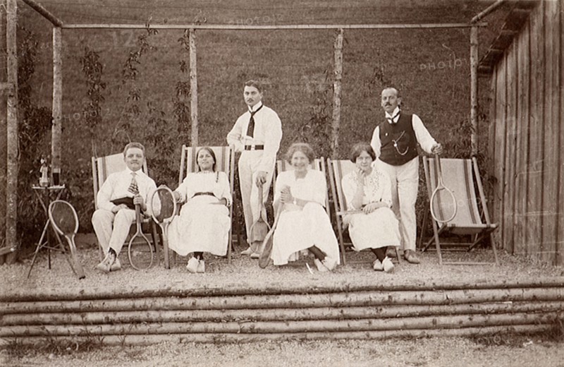Three tennis couples posing on lounge chairs.