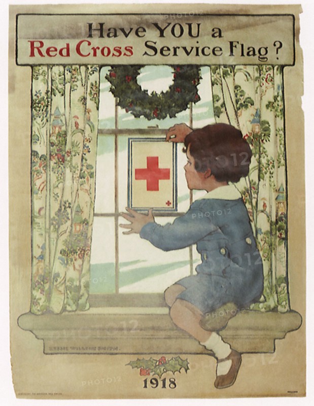 Boy placing Red Cross Service Flag on Window.