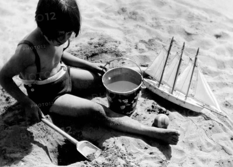italy, seaside summer camp, little girl playing on the beach, july 1939