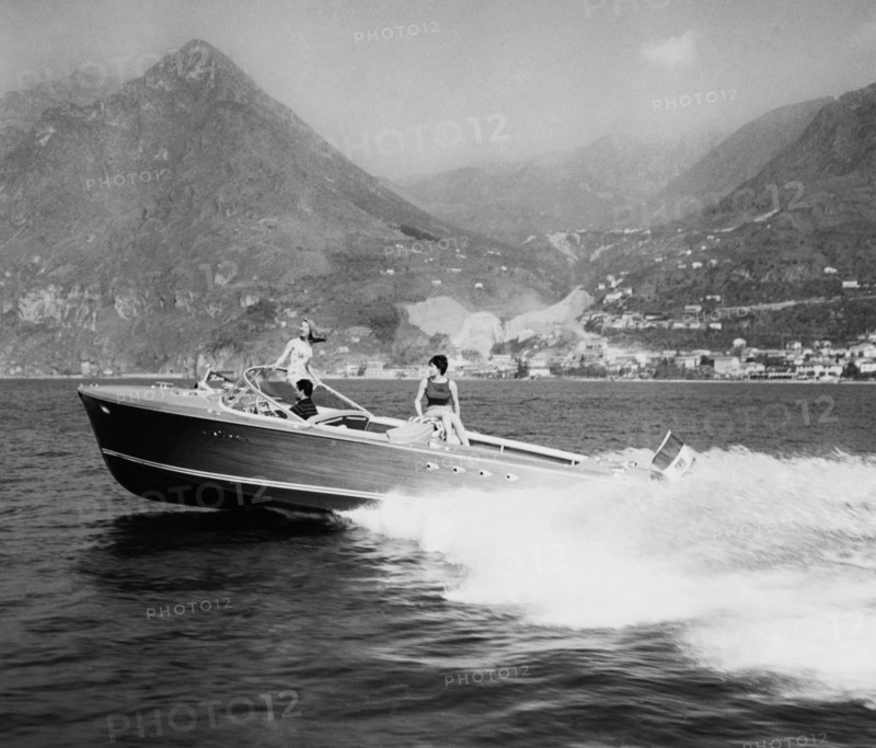 touristes au bord du lac sur le bateau à moteur triton du chantier naval riva à sarnico, 1961