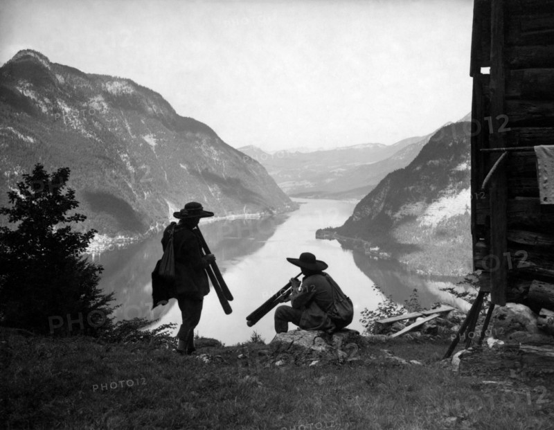 Two shepherds with old musical instruments made from roots. lake hallstatt. austria 1920