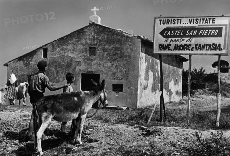 Italy. emilia romagna. entrance to the country castel san pietro. the town of bread. love and dreams. 1955