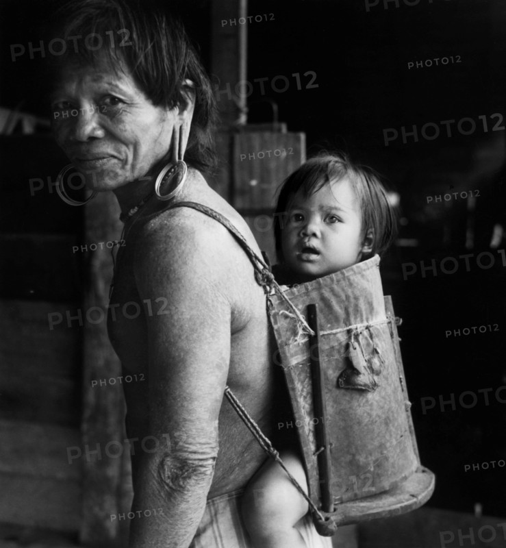British Asia. Borneo. A Dayak With His Son On His Back. 1955