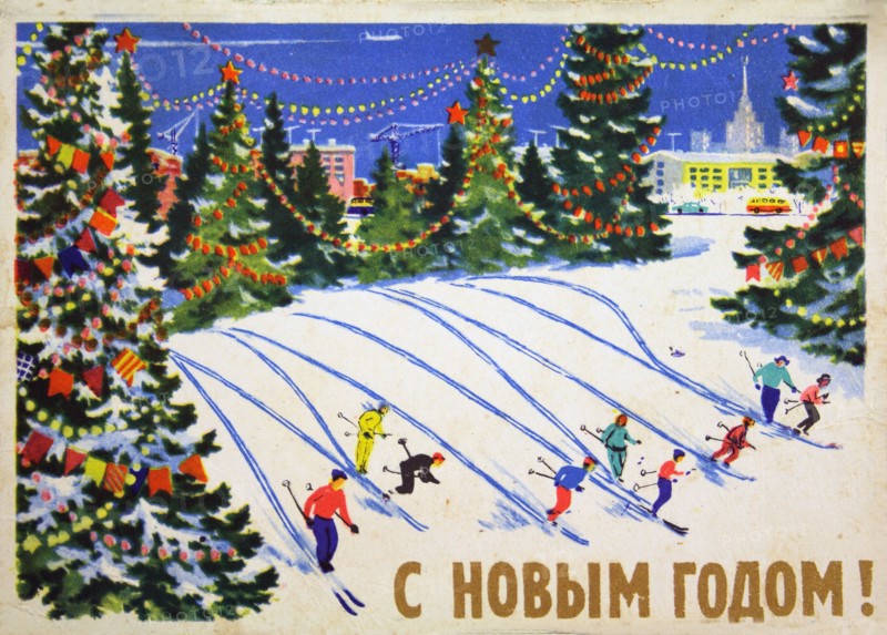 Skiers descend from a mountain surrounded by Christmas trees.