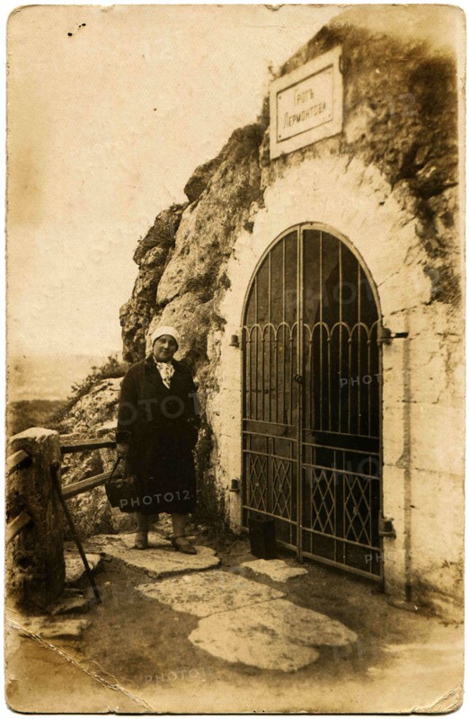 A woman stands near the entrance to the Grotto of Lermontov.