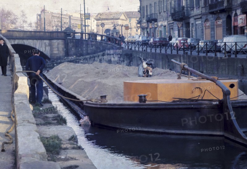 Italy, lombardia, milan, boat on naviglio canal carries sand