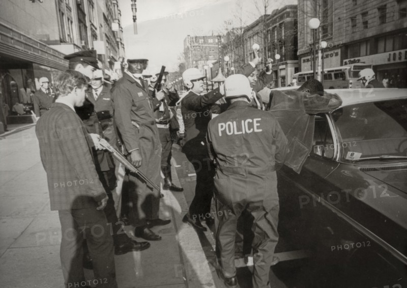 Suspect two black people looters are serched by police in downton washington, 1968