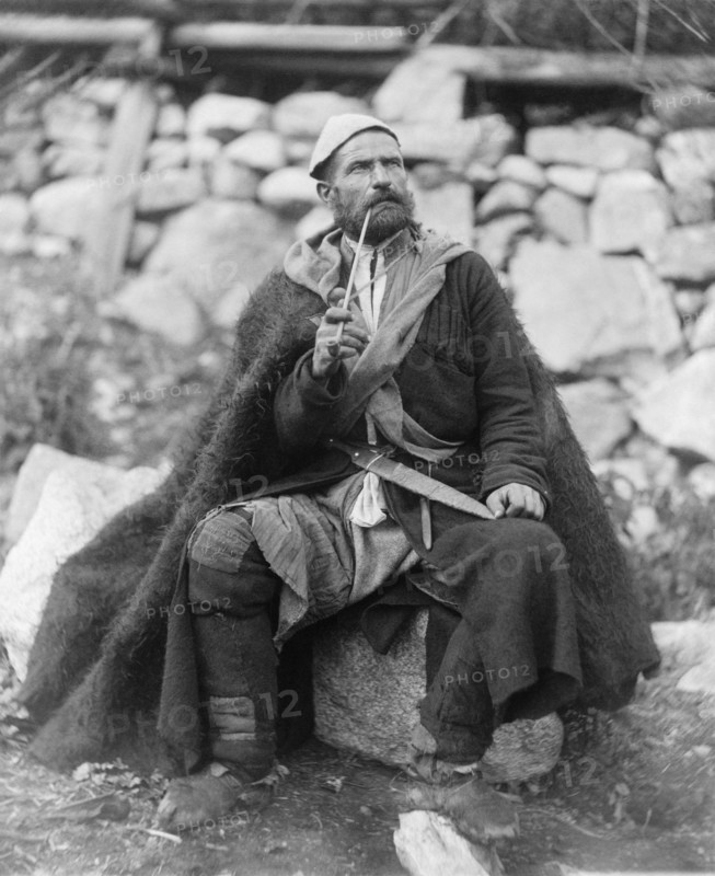 Old peasant with dagger and long smoking pipe