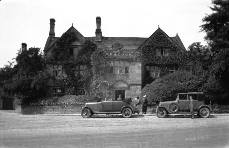 The Peacock hotel Rowsley with two cars parked in front from around 1925.