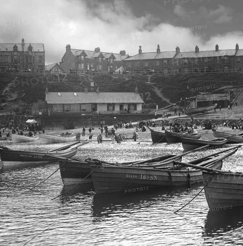 Cullercoats Bay with coble fishing boats and people on the beach.