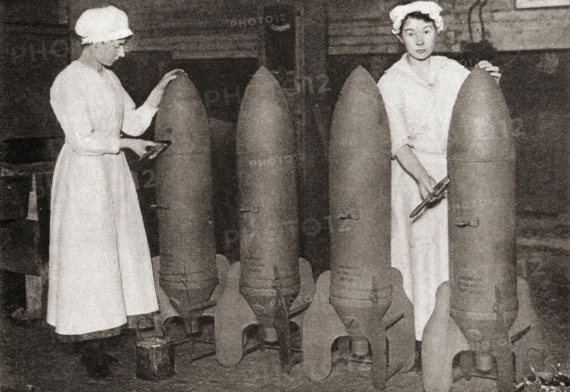 Women putting a coat of paint on aerial bombs during WWI.