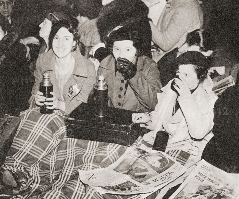 Three women have an early morning cup of tea in Piccadilly Circus.