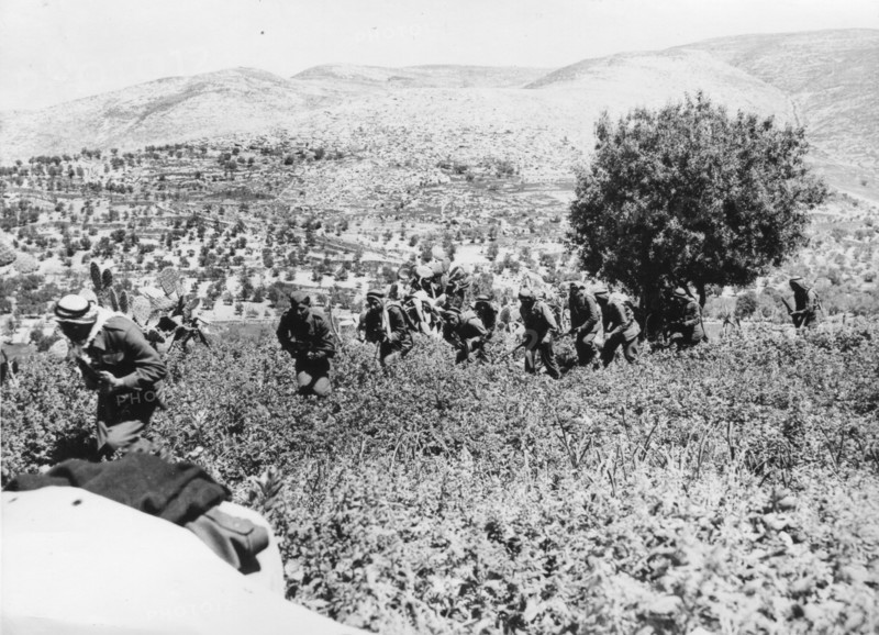 Arab Army of Liberation soldiers march across fields near Castel, east of Jerusalem.