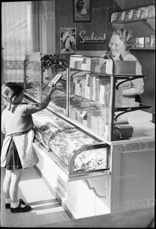 Girl buying chocolate; around 1943.