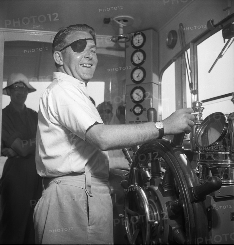 British war invalid at the helm of a tourist boat in Weggis, 1948