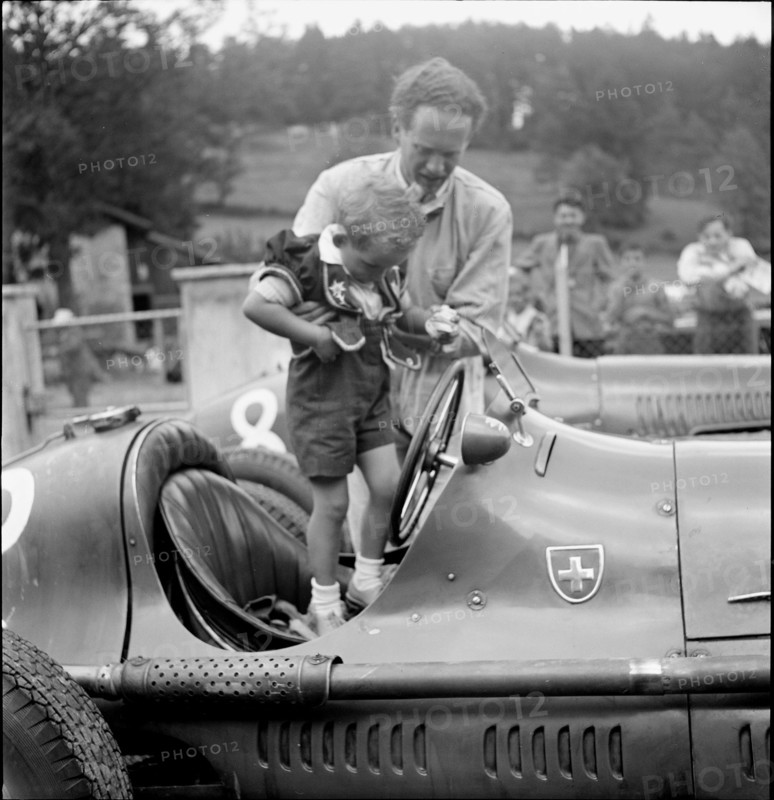 Emmanuel de Graffenried and son Leo in racing car, 1950