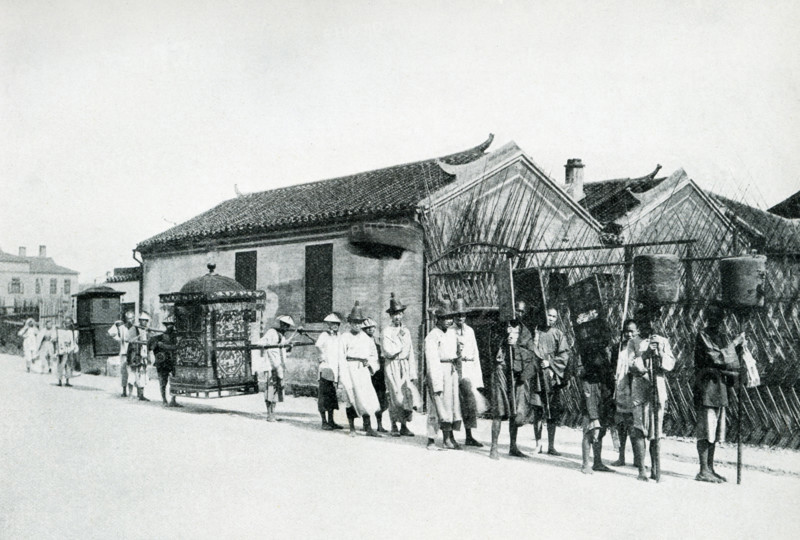 Wedding Procession in China. The caption of this 1900 photo reads:  “Wedding Procession.  Bride in sedan chair carried by several men In this air-tight affair she is locked up to be carried to where ceremony to take place No one allowed to see her during procession.”.