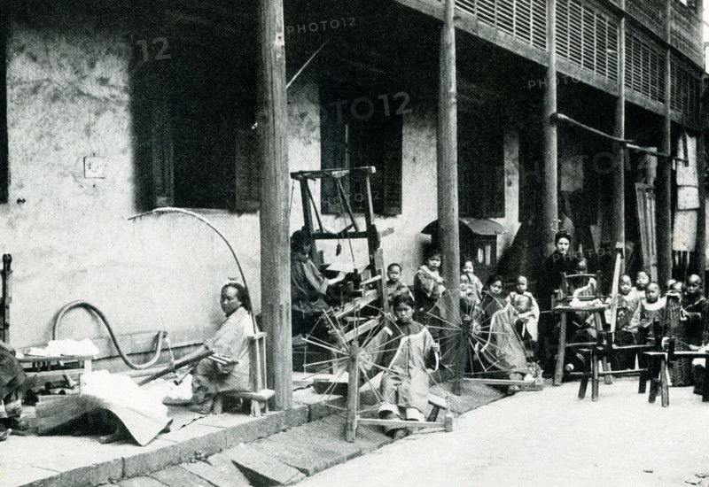 Christian Mission Industrial School.  This photo dates to 1900.  It shows a young woman missionary teaching children to spin and weave. The missionaries at ther school also taught the industries and laws of health and the Christian religion.