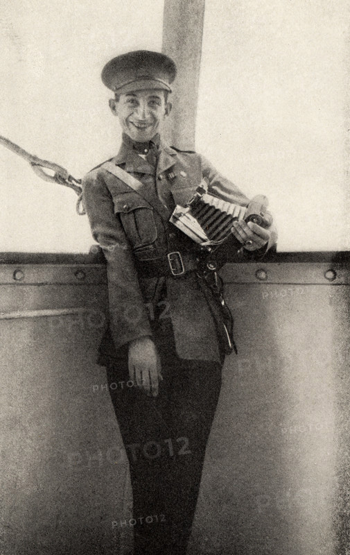 This photo shows Private Peat who fought in World War I. The caption reads: Still smiling though his right arm useless.  It appeared in Harold R Peat's book 'Private Peat' published in 1917.