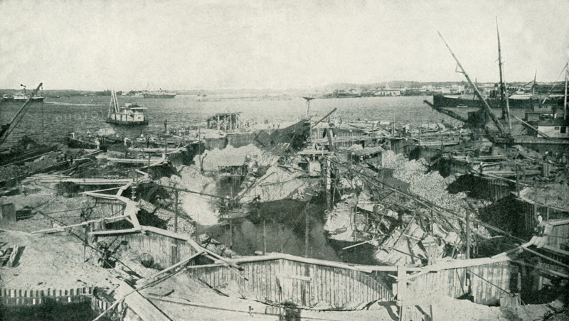 The photo dates to before 1922. The caption reads: A general view of the cause of the Spanish-American War, the cofferdam built to permit a thorough examination, which proved the theory that the disaster was caused by a sunken mine or torpedo. After this inspection, the wreck was cut up, floated out, and sunk in the Gulf of Mexico.