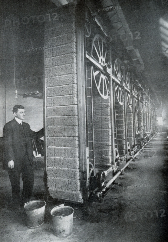This photo dates to 1922. The caption reads: The match sticks are prepared, dipped in the ignition composition and dried by this machine. The matches are removed and packed in boxes by automatic machinery so that manual labor is pratically eliminated in the manufacture.