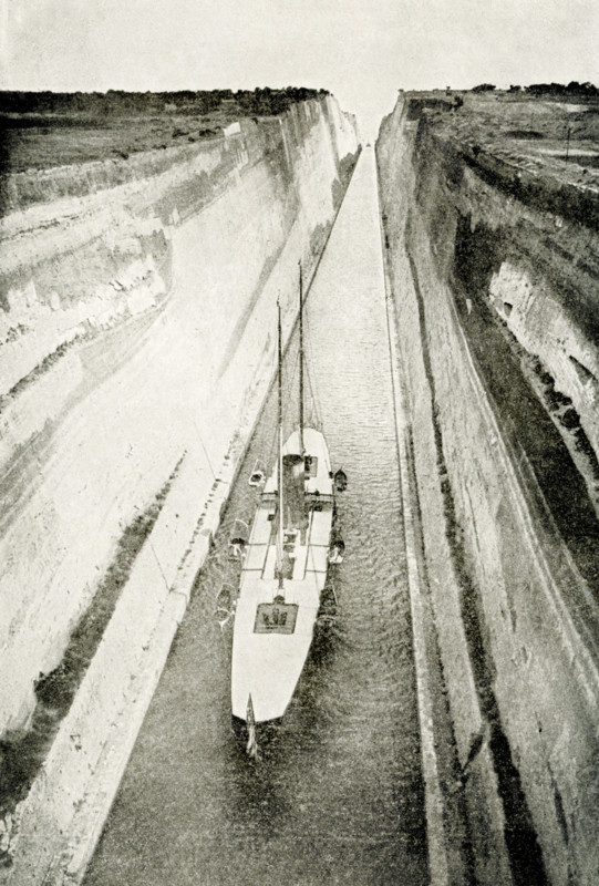 The 1912 caption reads: ""Canal that Nero Dreamed of - This is one of the wonderful canals which helped to shorten the journey around the world. It is the Corinth Canal, cut through the Isthmus of Corinth, and it enables ships to go to Athens and then on through the blue Aegean Sea to Constantinople without having to sail round the rocky coast of Morea, in the south of Greece. When the Roman emperor Nero was young and energetic, he caused this canal to be be begun, but the work was put off and never resumed until our own time. It is 3.2 miles long, and was cut through limestone rock in one part 250 feet above the level of the sea. The canal is 100 feet wide and 26 feet deep, and jit saves ships 200 miles, Sailing through it from Greece, the traveler comes out in full view of the city where Paul made tents."" Under Nero, the canal was begun in 67 AD, but he was assassinated and work stopped. In 1881, the Greeks began construction and first shipped passed.