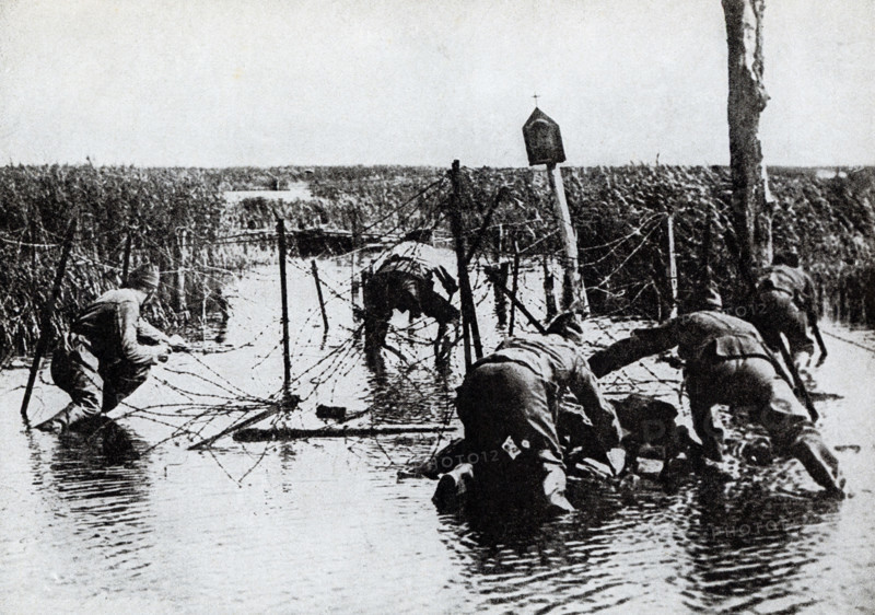 This photo dates to the First World War. The caption reads: Americans cutting wire entaglements prior to a drive.