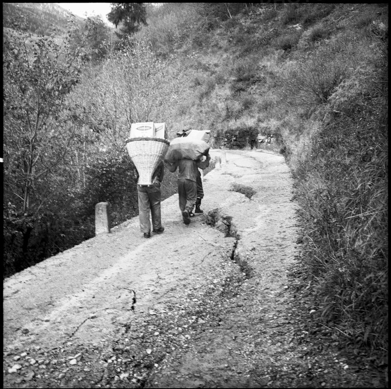 Landslide in the Misox valley, men carrying goods to supply the population; 1960.