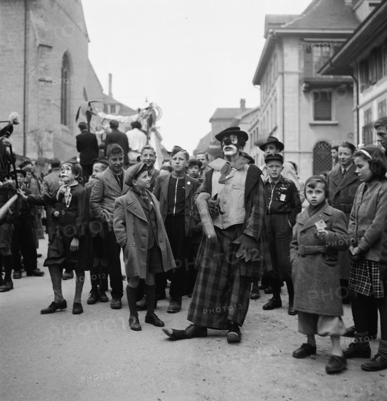 Clown and children at carnival parade in Payerne, 1946.