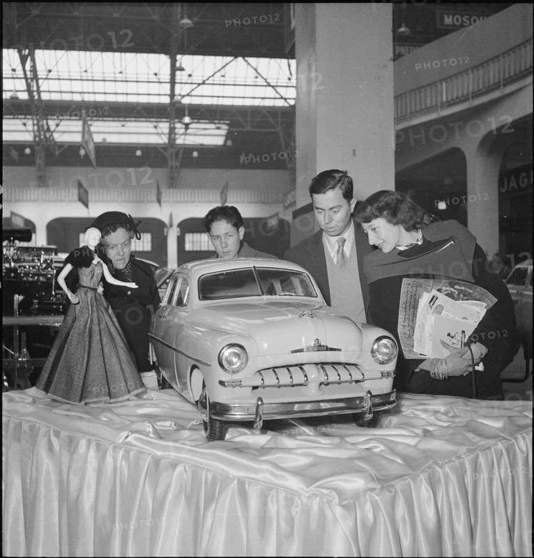 Visitors admire exhibited model car.