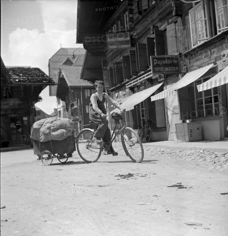 Boy on bike pulling a wooden handcart, 1940.