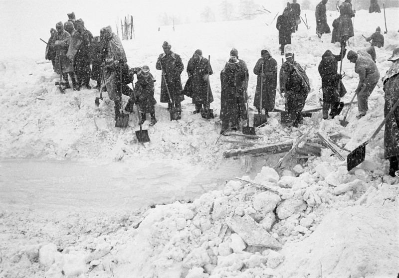 Reckingen: search-troupe, row of people with shovels; 1970.