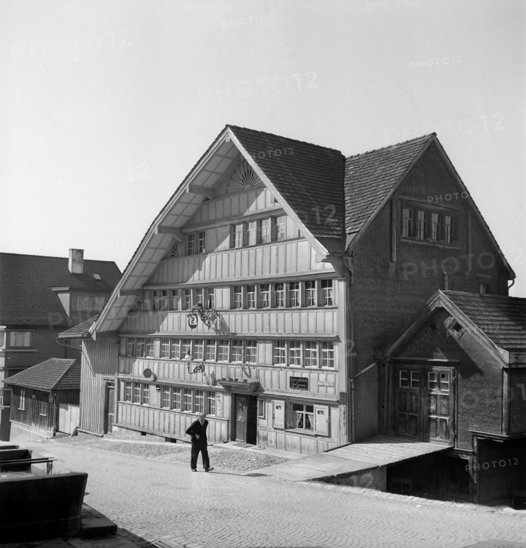 Herisau; Old man walking in a street; 1945.