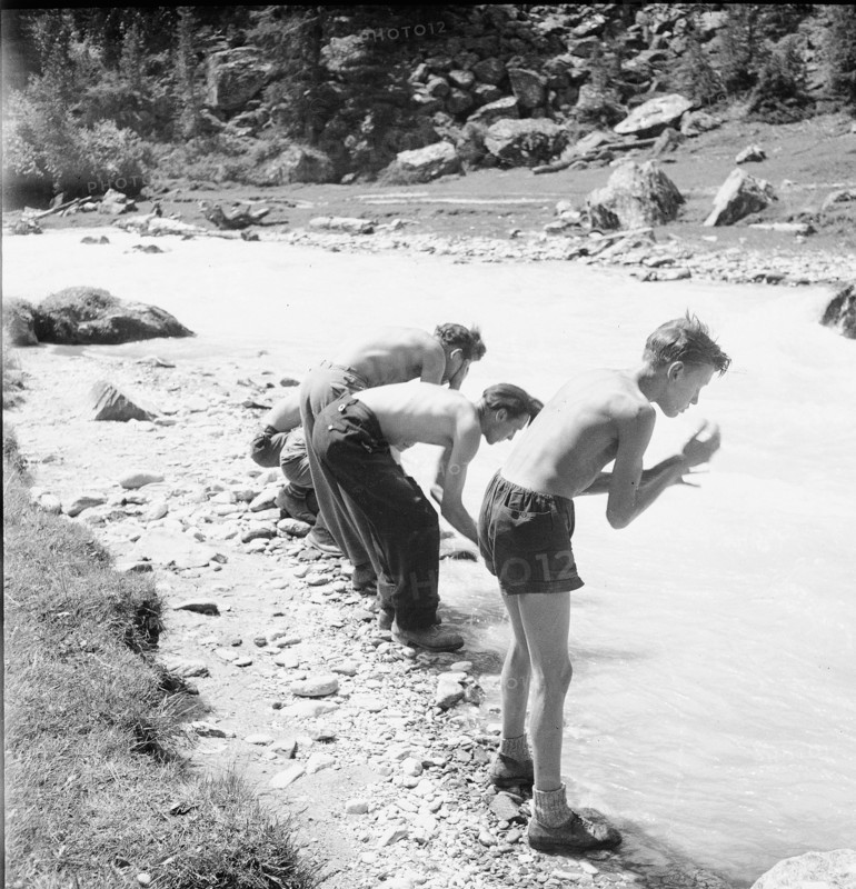 Camp, boys wash themselves in rivulet; 1944