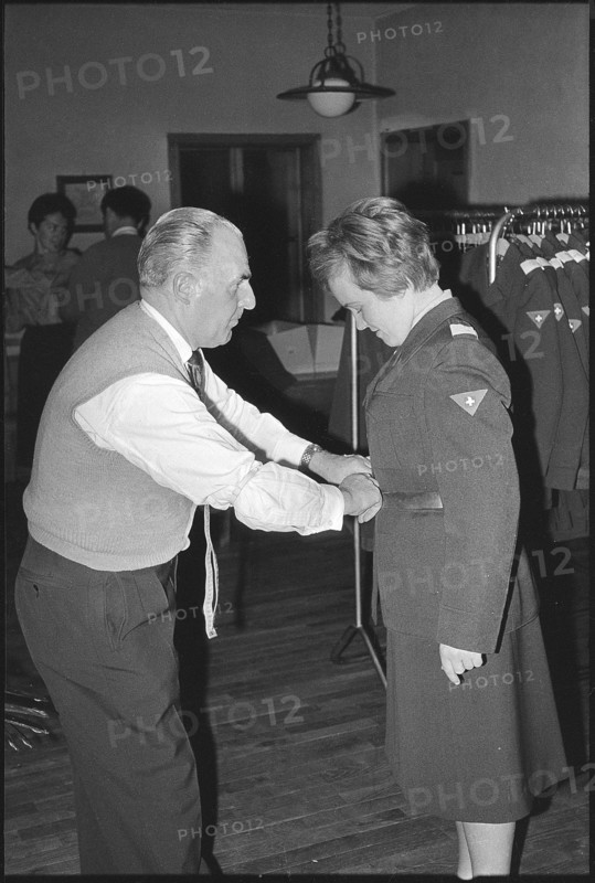 Woman soldier getting uniform, armory Kreuzlingen 1964