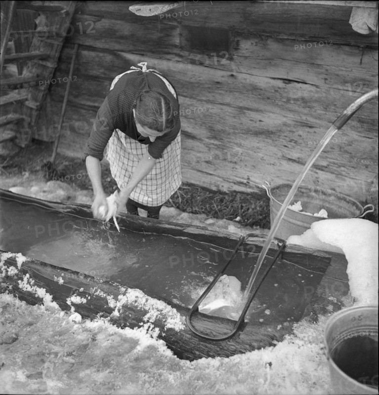 Lötschental, woman hand washing at fountain, wash day; 1941