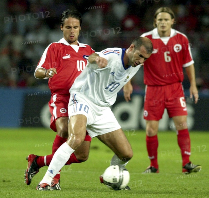 Photo: walter l. keller, 20.8.2003, geneva: friendly match switzerland - france 0:2. zinedine zidane (m, fra) fighting for the ball against ricardo cabanas (l, sui), johann vogel (r) watched.