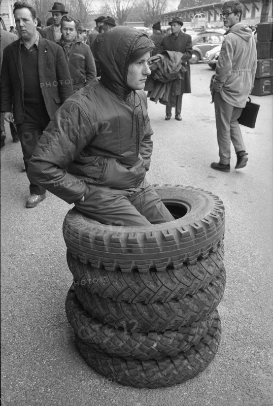 Thun, sale of used army equipment, young man with car tires; 1969