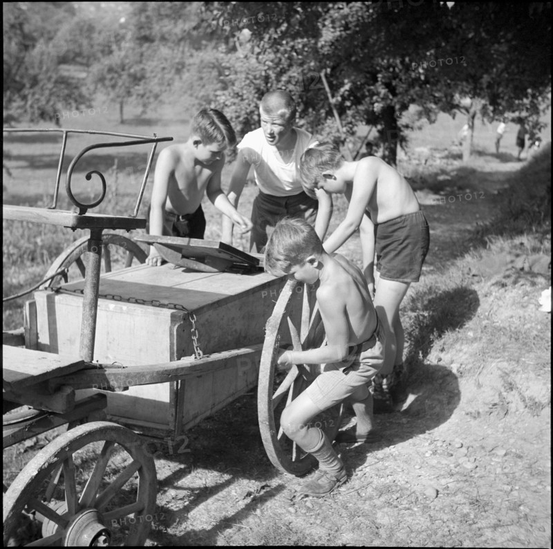 Children transporting peat briquettes; 1940
