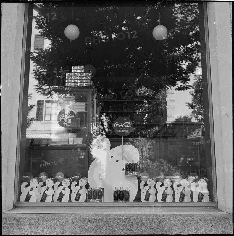 Product advertising, CocaCola advertising in shop windows; 1952