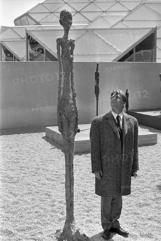 Man beside sculpture of Giacometti; Expo 1967.