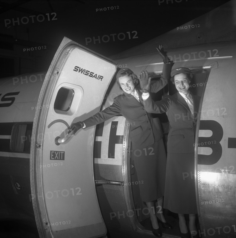 Swissair hostesses waving out of airplane door 1953.