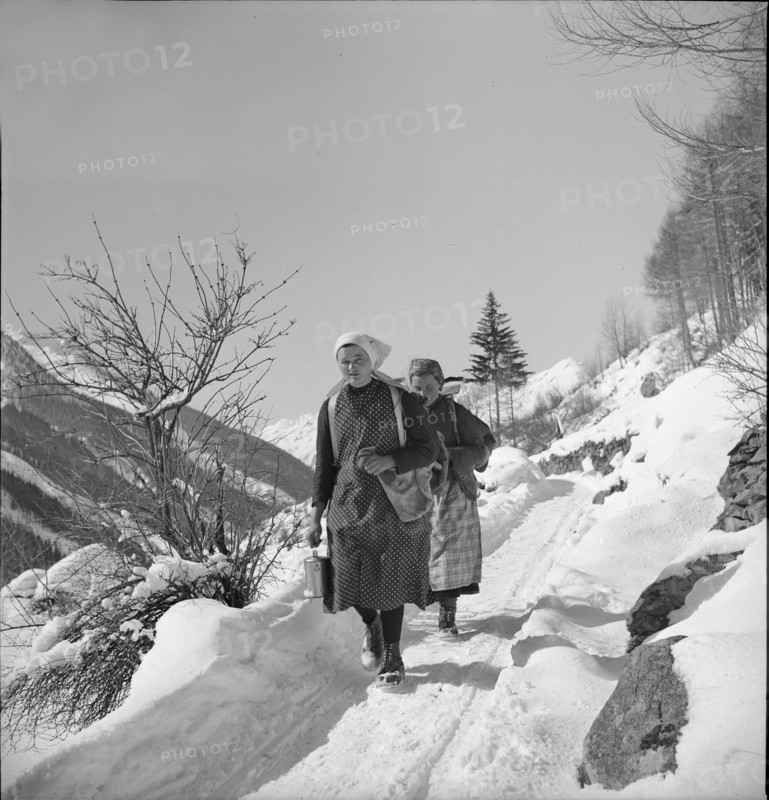 Lötschental, Two women walking on snowy path; 1940.