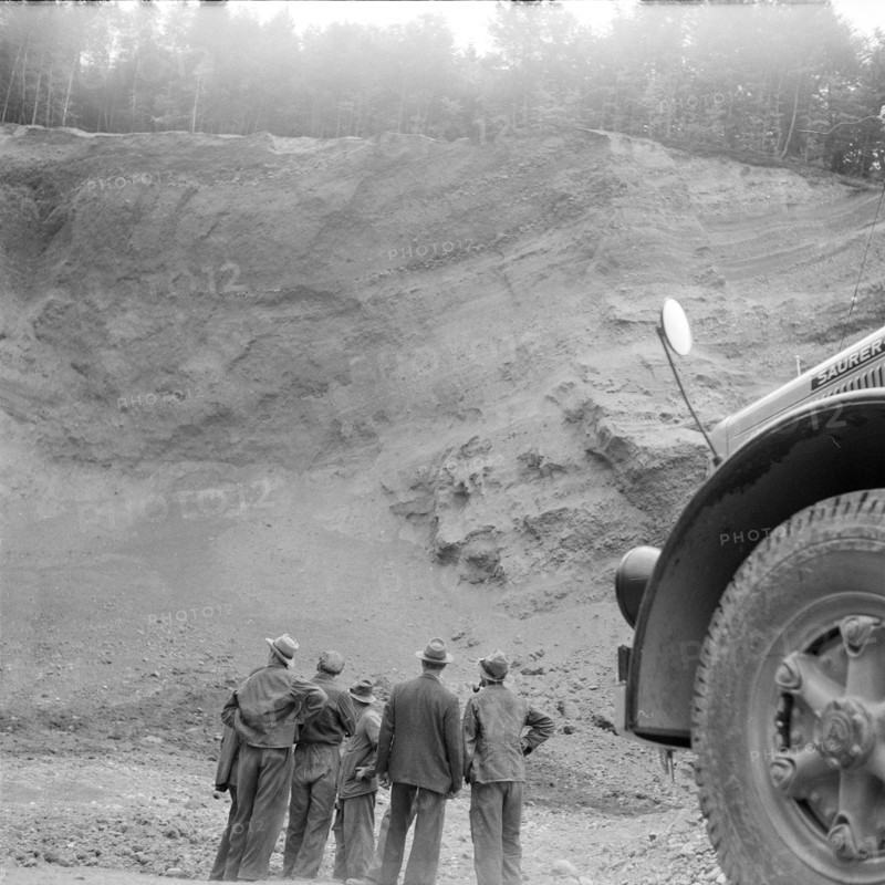 Men looking at Schoeftland gravel pit after succeeded blasting; 1955.