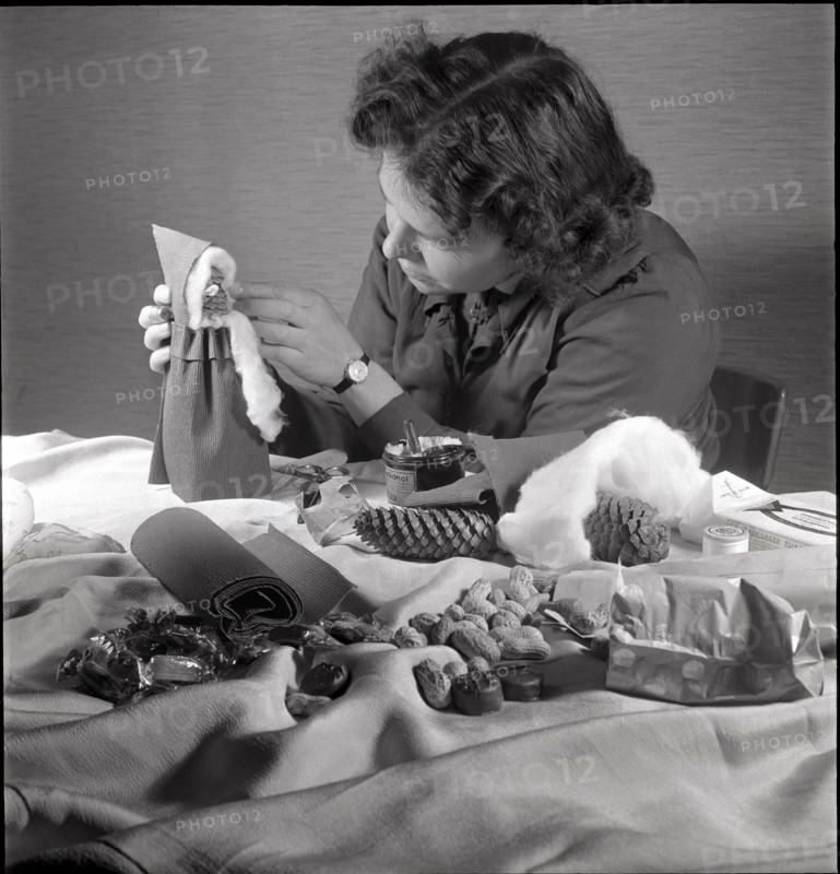 Woman making a Santa Claus doll in 1944.