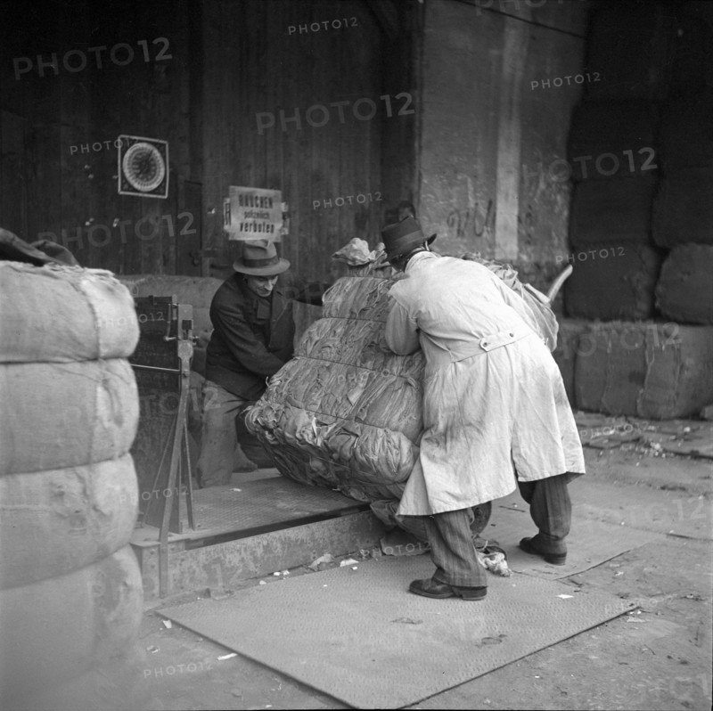 WW 2: economy of war; weighing of bundle of rag, rags.